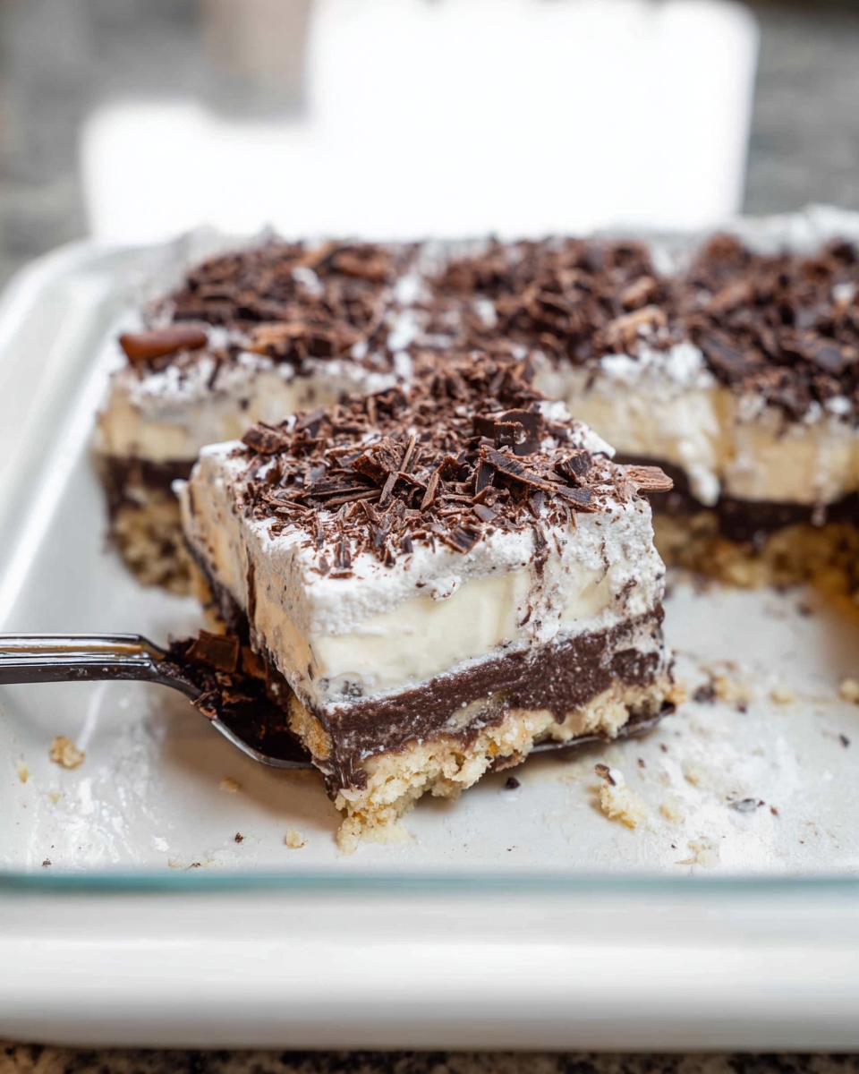 A slice of layered chocolate dessert with whipped cream and chocolate shavings, perfect for Thanksgiving desserts.