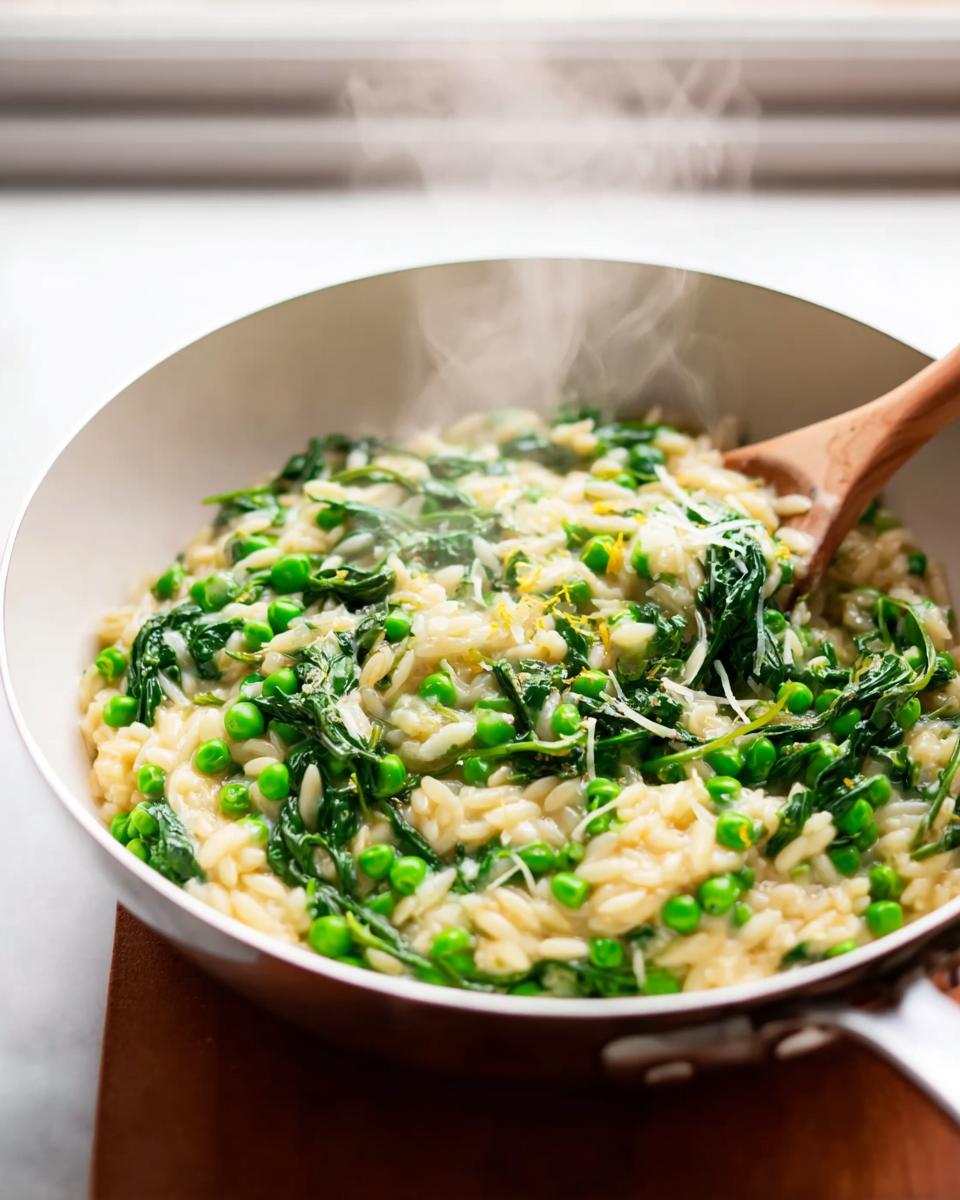 A close-up of creamy pea and spinach risotto, a perfect 20-minute dinner idea, steaming in a pan with a wooden spoon.