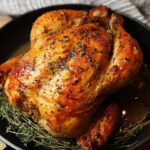 A golden-brown, juicy 5-Ingredient Chicken roasted to perfection in a cast-iron skillet with fresh thyme.