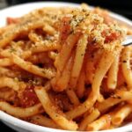 Close-up of a fork lifting a portion of delicious 5-ingredient pasta with tomato sauce and toasted breadcrumbs.