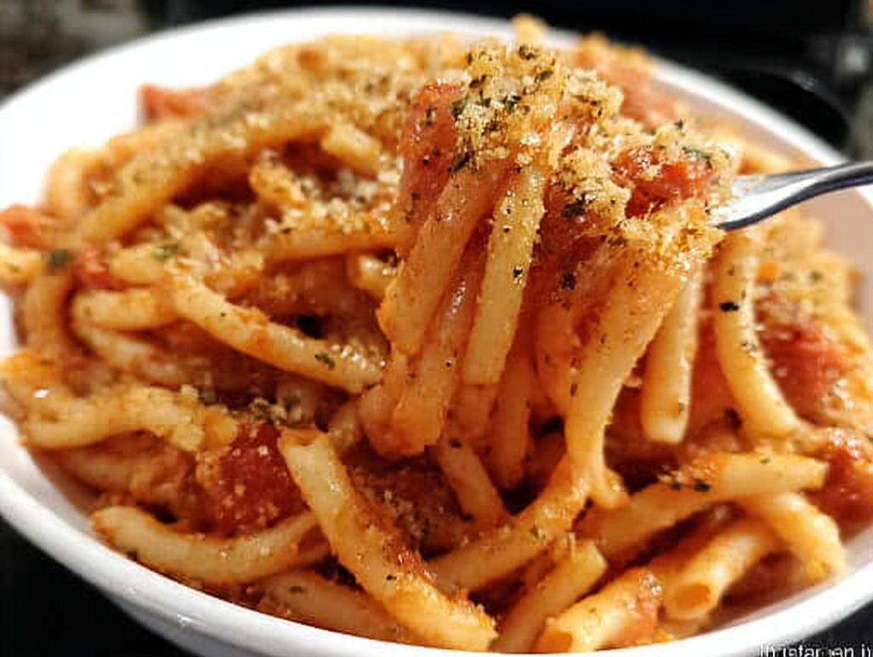Close-up of a fork lifting a portion of delicious 5-ingredient pasta with tomato sauce and toasted breadcrumbs.