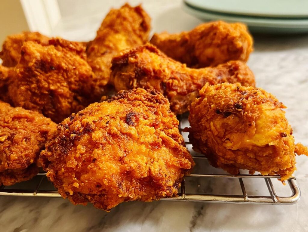 A close-up of perfectly fried chicken pieces, showcasing a crispy golden-brown exterior and juicy interior, embodying the Best Chicken 2025.