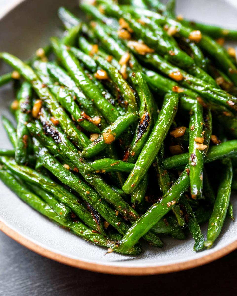 Close-up of Best Thanksgiving Green Beans 2025, glistening and tossed with garlic.