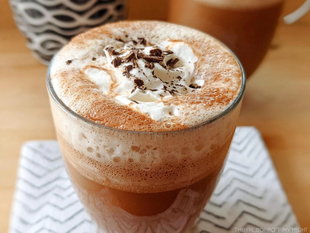 A close-up of a refreshing, blended Mocha Frappuccino topped with whipped cream and chocolate shavings.