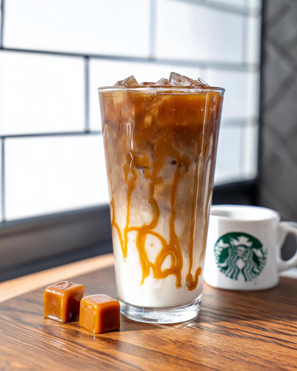 A tall glass of Café-Style Iced Caramel Macchiato copycat with caramel drizzle over ice and milk, next to two caramel squares.