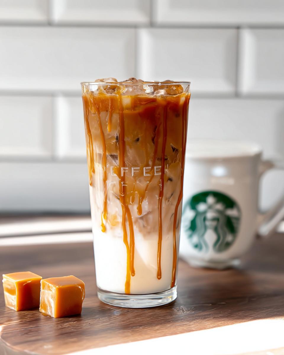 A tall glass of Café-Style Iced Caramel Macchiato with caramel sauce dripping down the sides, next to two caramel squares.