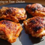 Four perfectly cooked chicken thighs with crispy, golden-brown skin, ready to be served.