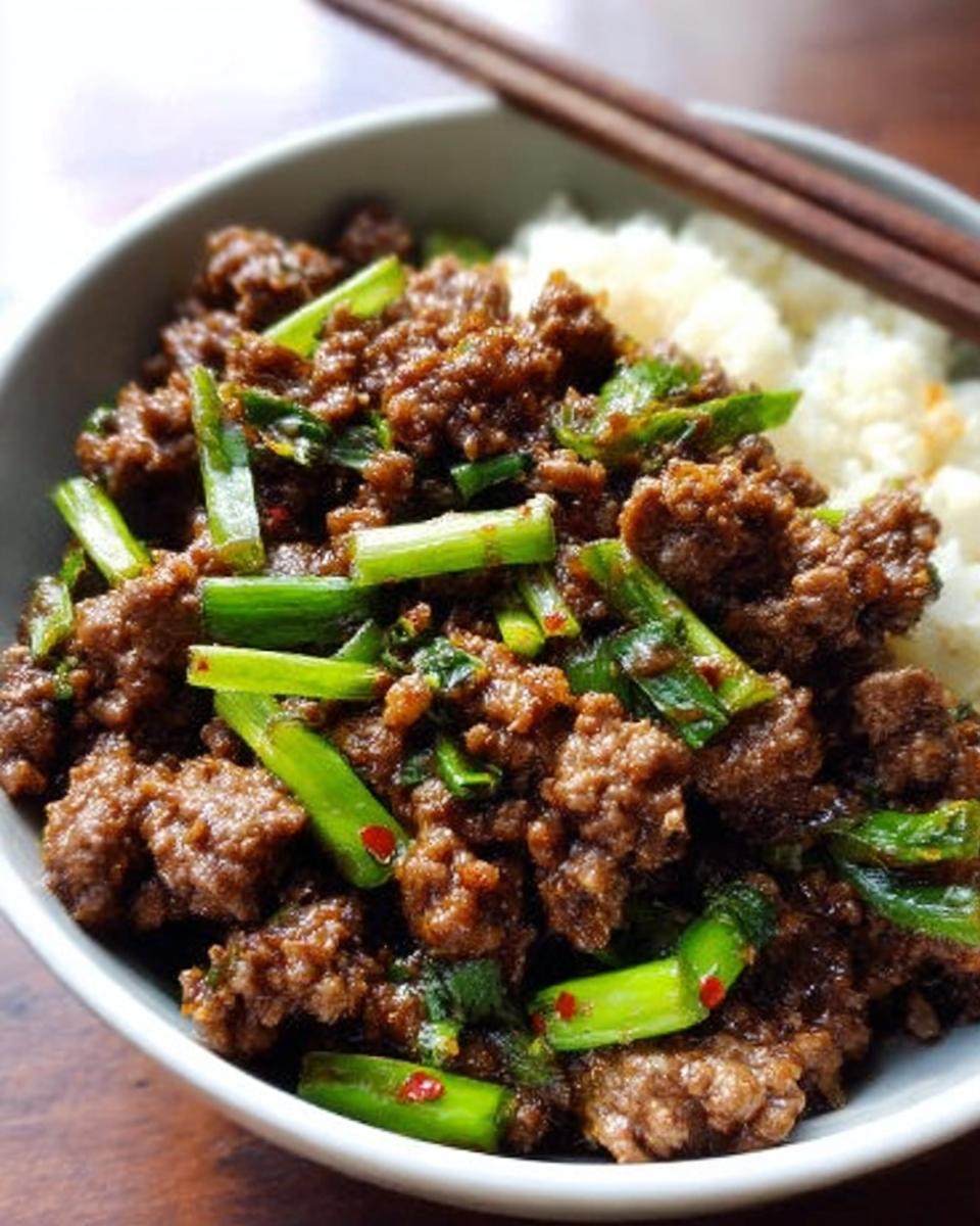 A bowl of ground beef recipe with rice and green onions, perfect for quick weeknight meals.