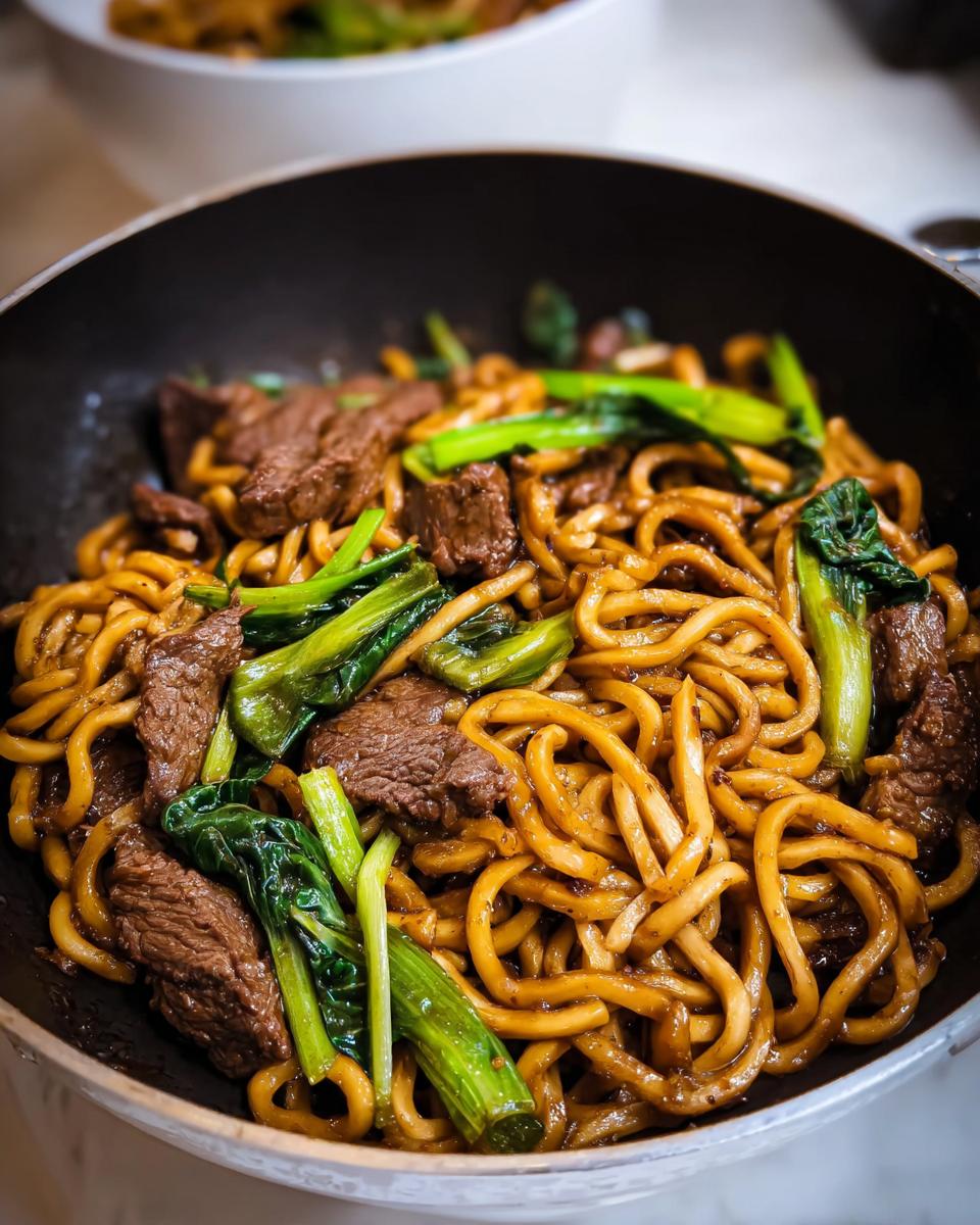 Close-up of a one-pan dinner idea featuring beef and noodles stir-fried with green vegetables.