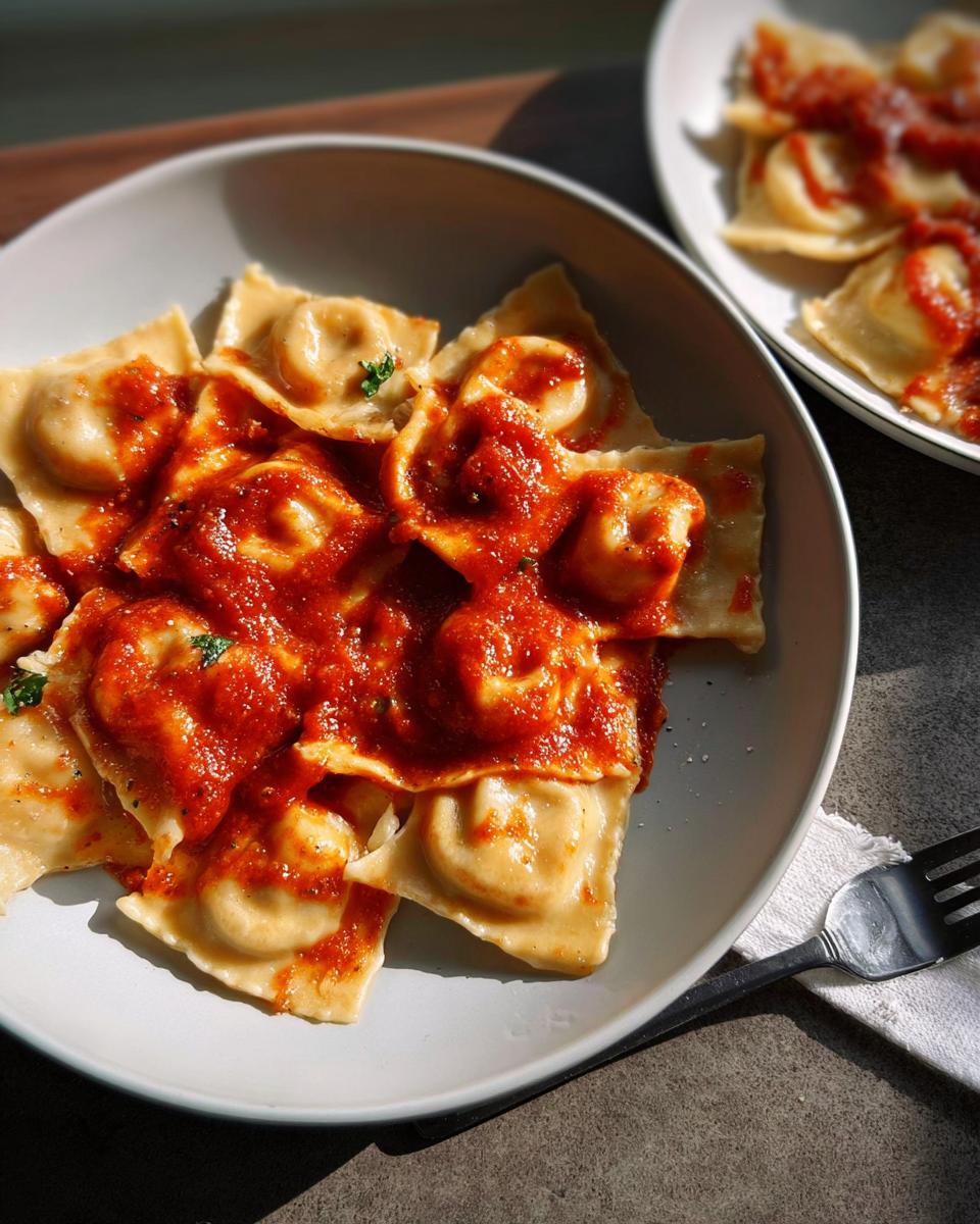 Close-up of delicious ravioli with rich tomato sauce, a key element in perfect pasta recipes.