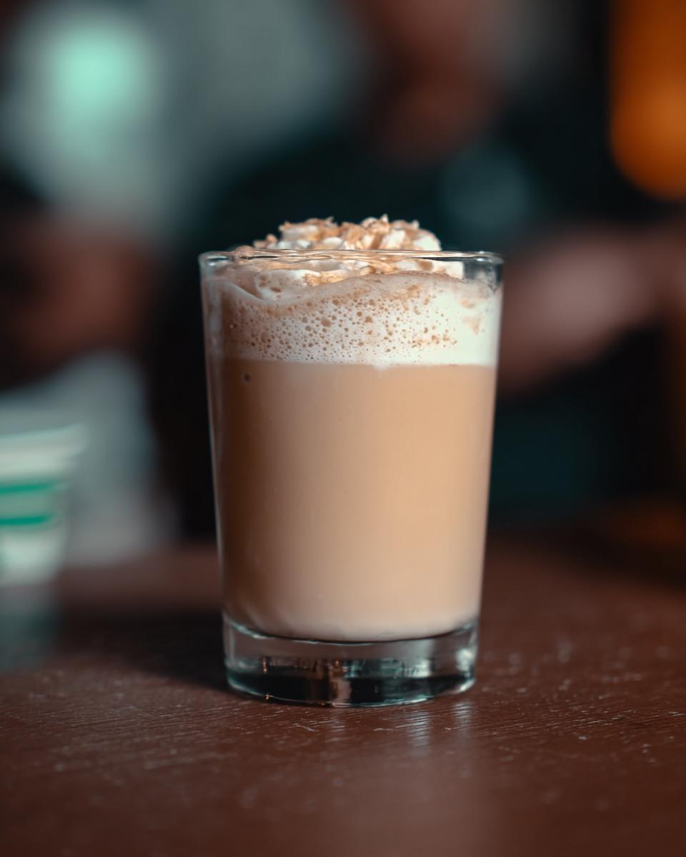 A perfect Starbucks drink topped with whipped cream and a sprinkle of cinnamon.
