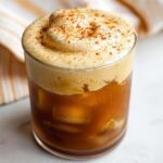 A glass filled with iced coffee topped with thick, foamy pumpkin cream and sprinkled with spice, a perfect Pumpkin Cream Cold Brew.