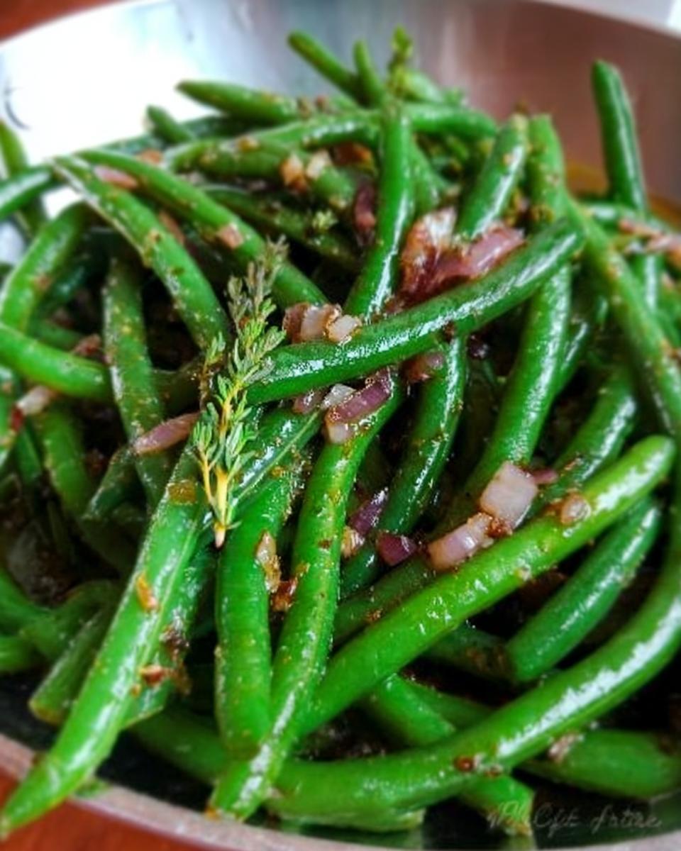 Close-up of vibrant green beans tossed with red onion and herbs, ready for Restaurant-Style Thanksgiving Green Beans at Home.