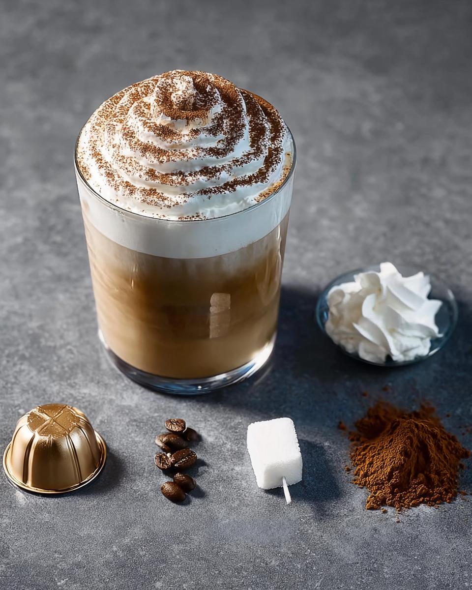 Ingredients for a Starbucks drink: coffee capsule, beans, sugar cube, cocoa powder, and a whipped cream topped latte.