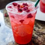 A refreshing pink restaurant-style Starbucks drink at home, filled with ice, strawberries, and topped with dried fruit.