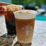 Two Starbucks iced drinks with caramel drizzle and whipped cream, featuring the Starbucks logo.