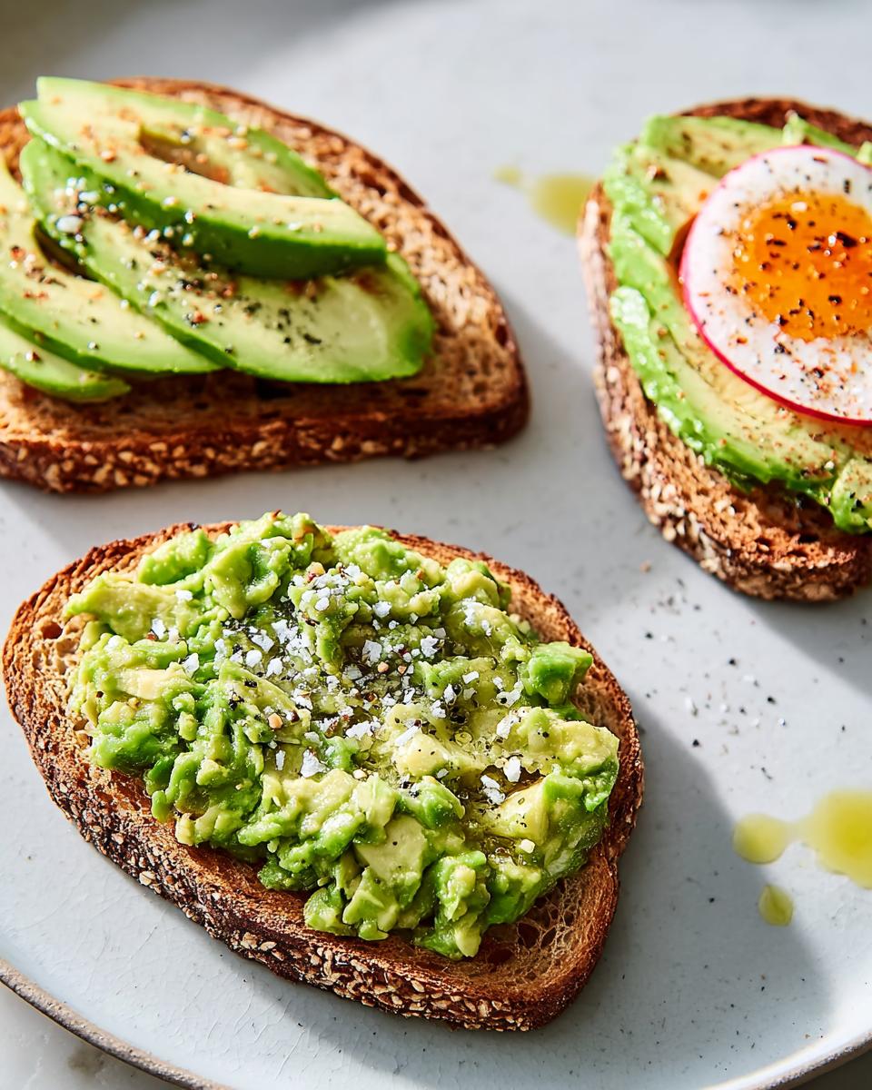 Three slices of healthy Avocado Toast on whole grain bread, featuring mashed, sliced, and egg-topped variations.