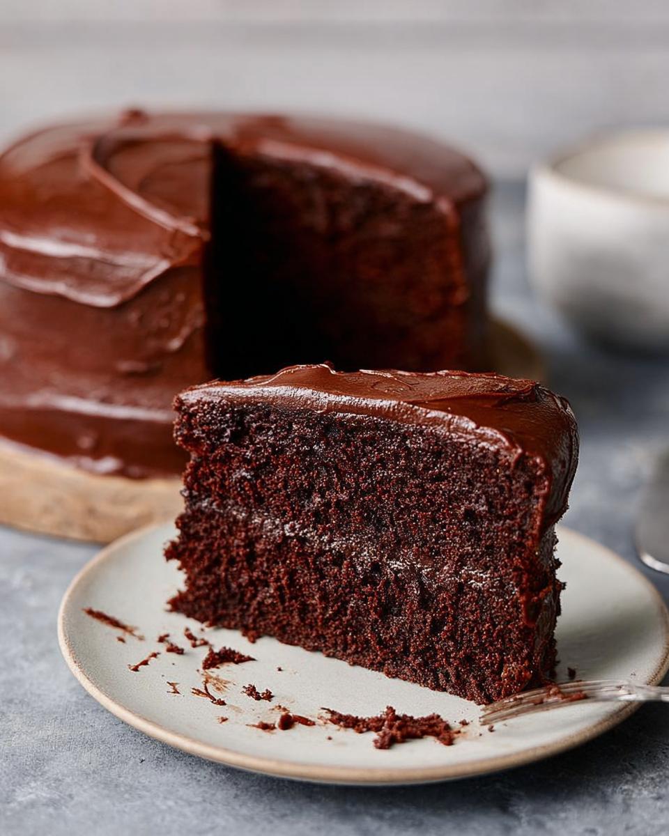 A slice of rich, moist chocolate cake with glossy chocolate frosting, part of 7-Ingredient Cake Ideas Recipes.