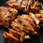 Close-up of sliced air fryer chicken breast, seasoned and perfectly cooked, showing juicy white meat.