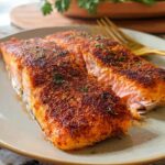 Two perfectly baked salmon fillets with a crispy, seasoned crust, part of The Ultimate Salmon Recipes Guide for Beginners.