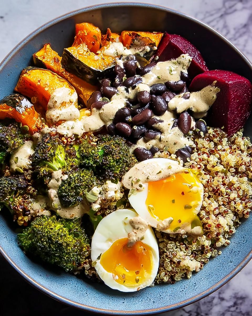 A vibrant bowl of breakfast ideas recipe featuring quinoa, black beans, roasted pumpkin, broccoli, beets, and soft-boiled eggs.