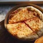 A simple cheese pizza, sliced and served on a plate, perfect for Pizza Night Recipes.