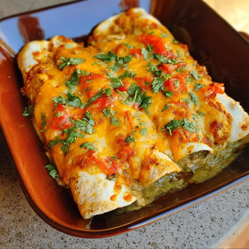 Close-up of cheesy chicken enchiladas topped with salsa and cilantro, perfect for chicken recipes meal prep.