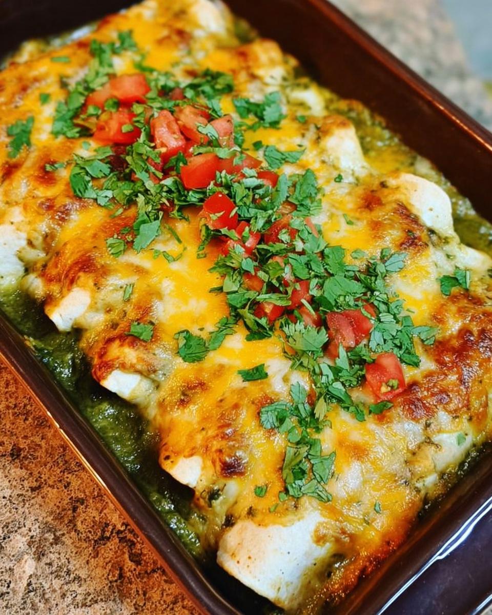Close-up of cheesy chicken enchiladas topped with fresh cilantro and tomatoes, perfect for chicken recipes meal prep.