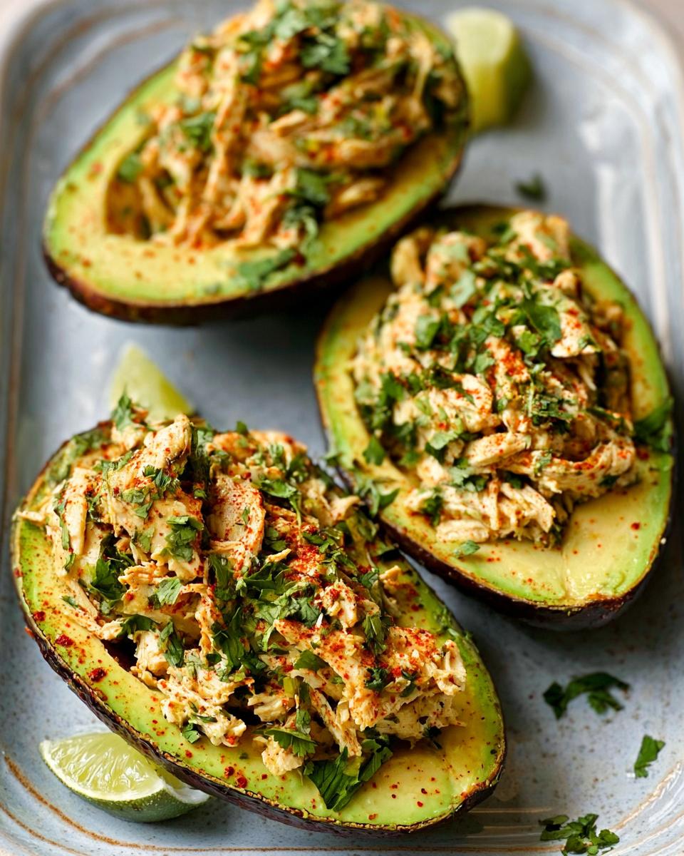Three avocado halves generously filled with shredded chicken salad and sprinkled with paprika and cilantro. Part of our Sandwich Ideas Recipes in 20 Minutes.