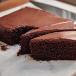 A decadent chocolate cake with rich chocolate frosting, sliced and ready to serve. A beloved cake idea.