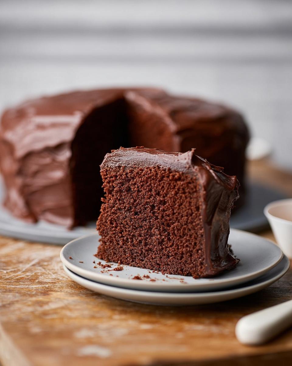 A slice of rich, moist chocolate cake with smooth chocolate frosting, part of 7-Ingredient Cake Ideas Recipes.