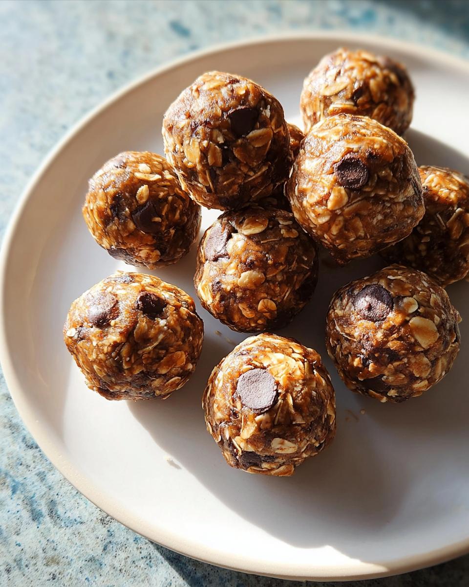 Close-up of chocolate chip energy balls, a healthy breakfast idea recipe, on a white plate.