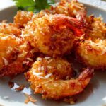Close-up of golden-brown crispy coconut shrimp on a plate, a perfect addition to your shrimp recipes.