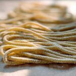 Close-up of freshly made pasta strands dusted with flour, ready for pro pasta recipes.