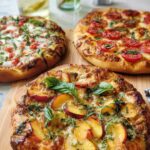 Three artisanal pizzas, including a peach and basil pizza, a tomato and basil pizza, and a tomato and mozzarella pizza, ready for pizza night.