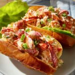 Two lobster roll sandwiches filled with fresh lobster salad and green onions, part of The Ultimate Sandwich Ideas Recipes Guide.