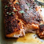 Close-up of a perfectly cooked salmon fillet with a seasoned crust, ready for a delicious salmon recipe.