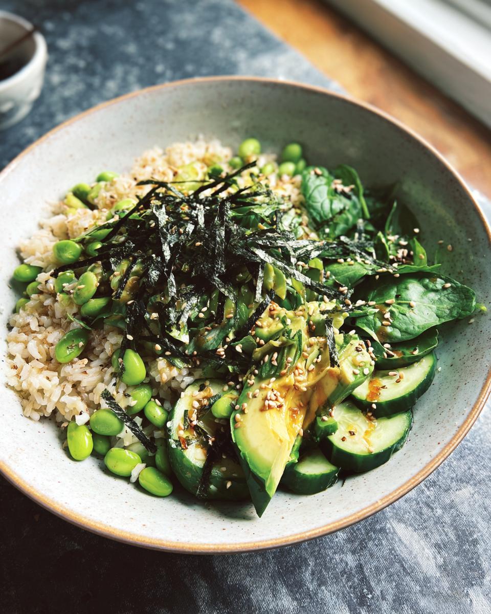 A vibrant rice bowl featuring brown rice, edamame, avocado slices, cucumber, spinach, and nori strips, part of The Ultimate Rice Bowls Recipes Guide for Beginners.