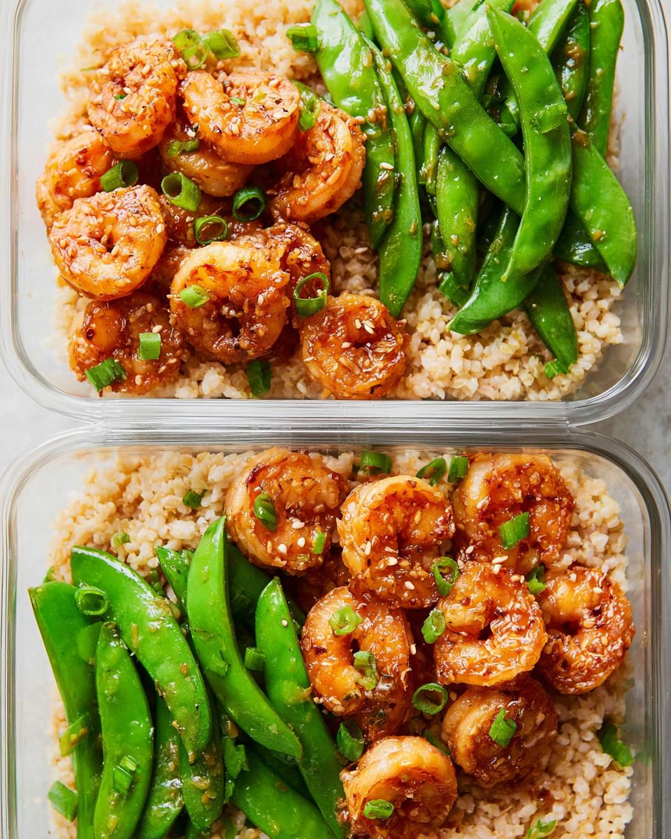 Two meal prep containers filled with brown rice, glazed shrimp, and snow peas, showcasing delicious shrimp recipes for meal prep.