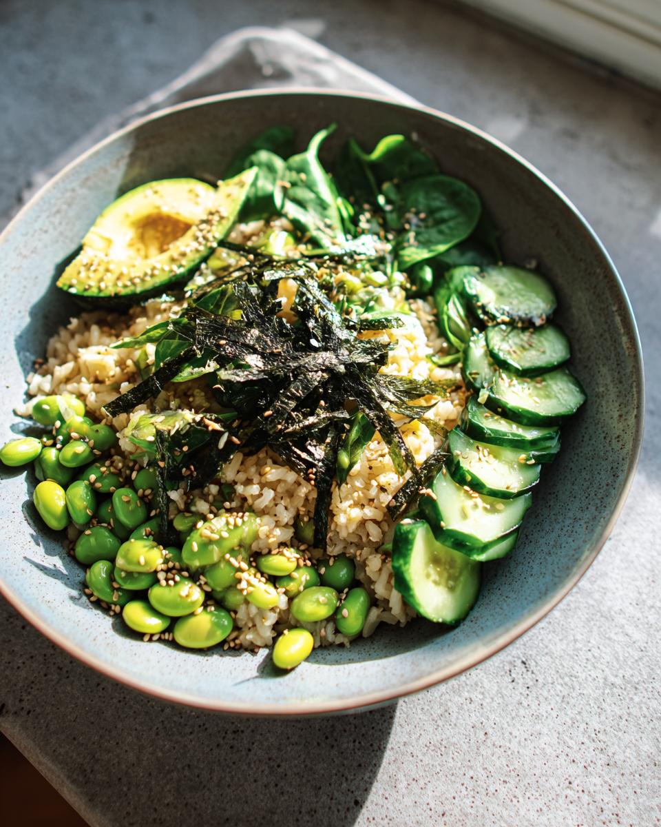 A vibrant rice bowl featuring brown rice, edamame, sliced avocado, cucumber, spinach, and nori seaweed, part of The Ultimate Rice Bowls Recipes Guide for Beginners.