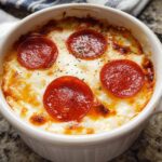 A close-up of a baked Cottage Cheese Pizza Bowl topped with melted cheese and pepperoni slices.