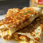 Close-up of two Cozy Cheesy Garlic Chicken Wraps, filled with chicken and melted cheese, sprinkled with parsley.