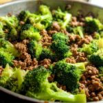 A close-up view of a Keto Hamburger Broccoli Skillet in a pan, showing ground beef mixed with fresh broccoli florets.