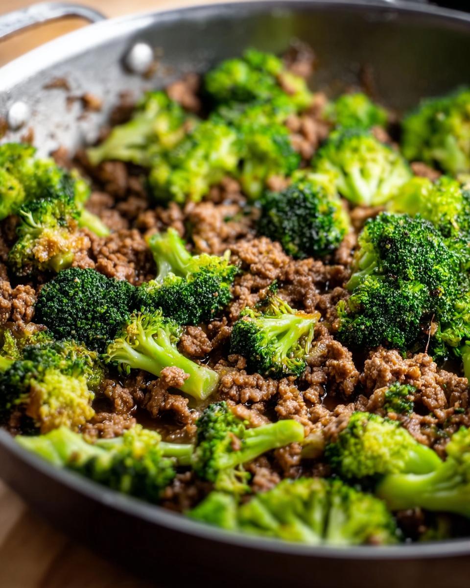 Close-up of a Keto Hamburger Broccoli Skillet in a pan, showing seasoned ground beef mixed with tender broccoli florets.