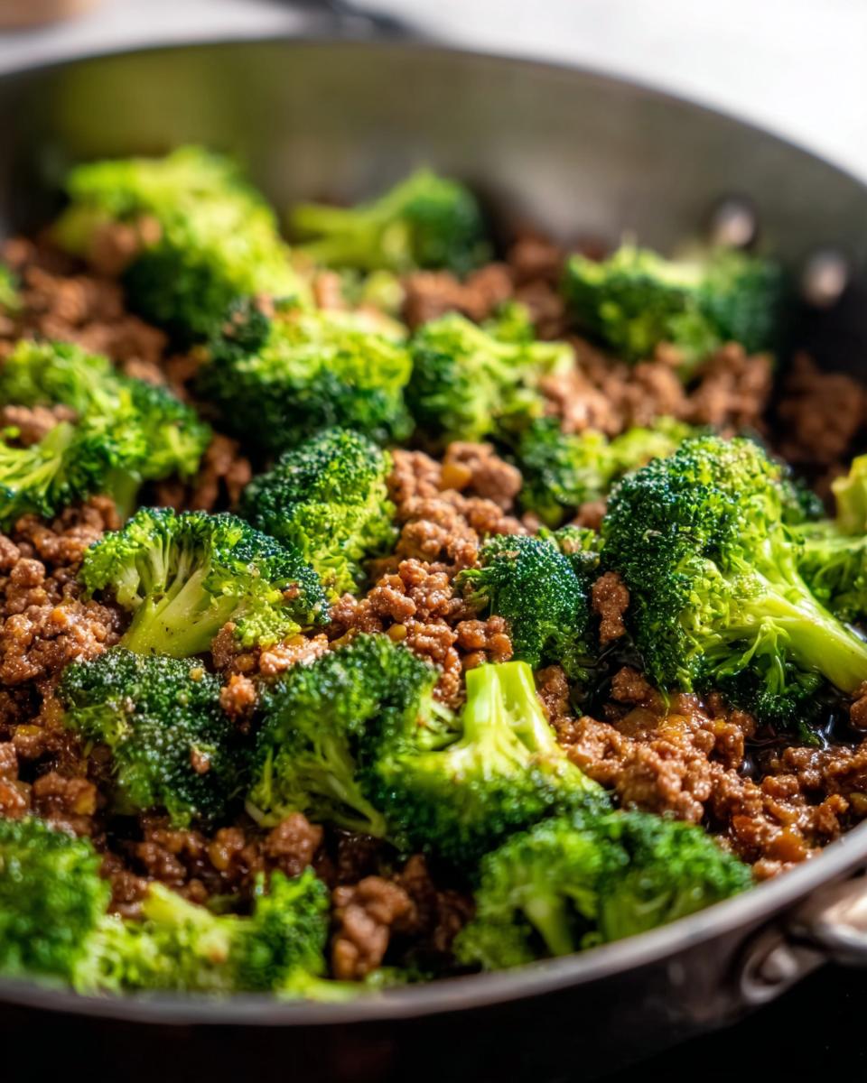 Close-up of a Keto Hamburger Broccoli Skillet in a pan, showing seasoned ground beef mixed with fresh broccoli florets.