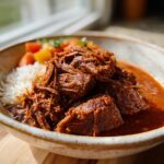 A bowl of Korean Style Pot Roast served with white rice and mixed vegetables, featuring shredded and cubed tender beef in a rich sauce.
