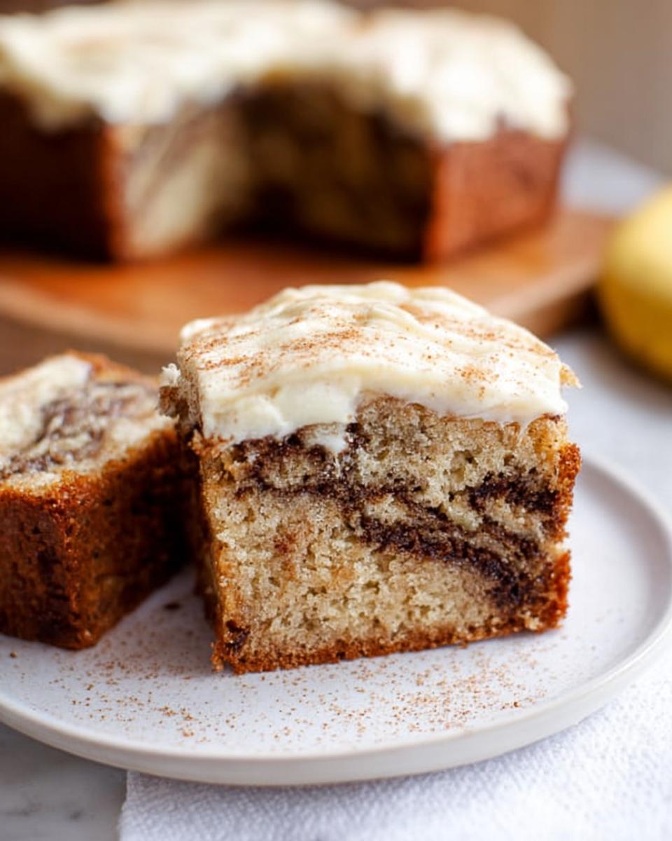 Slice of Banana Bread Brownies Made Easy with creamy frosting and cinnamon swirl.