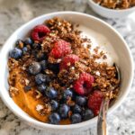 A Delicious Sweet Potato Breakfast Bowl topped with fresh blueberries, raspberries, and granola.