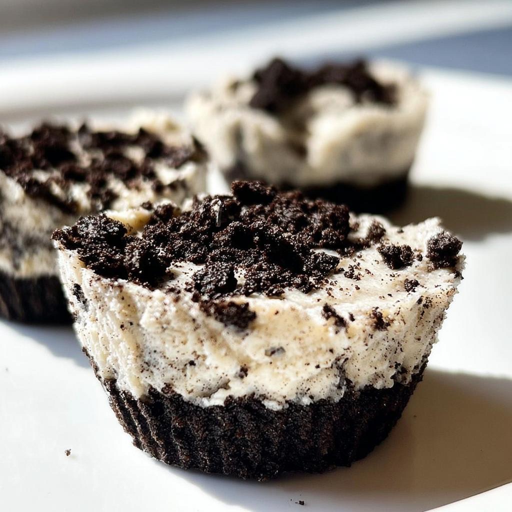 Close-up of three Healthy No-Bake Oreo Cheesecake Bites topped with crushed Oreo cookies.