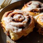 Close-up of fluffy high-protein cinnamon roll bread swirls topped with creamy icing.